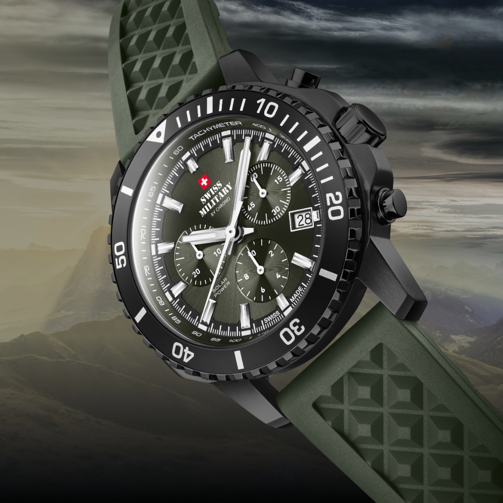 Rugged Solar chronograph watch SMS34113 with a black case, dark green dial, and textured strap, shown diagonally against a dramatic cloudy sky and mountain backdrop.